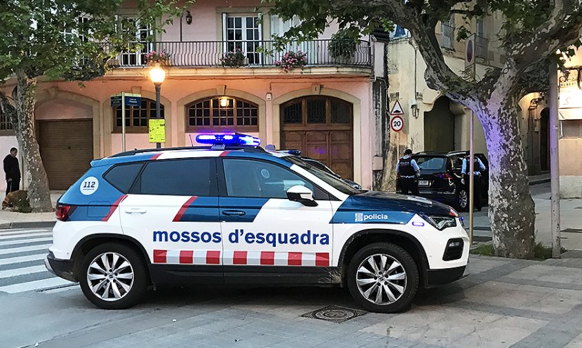 Vehicle dels Mossos en primer terme i al seu darrere es veu el vehicle abandonat a l'entrada del carrer de l'Hospital, ahir al vespre