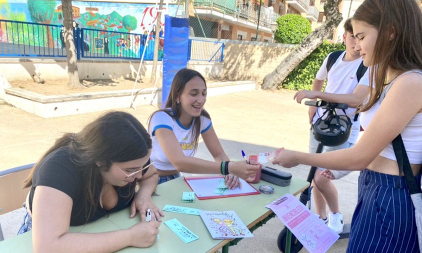 Les alumnes, a la sortida de l'escola, venent les seves revistes