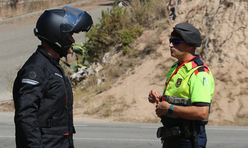 Motorista i agent dels Mossos conversant en un control policial