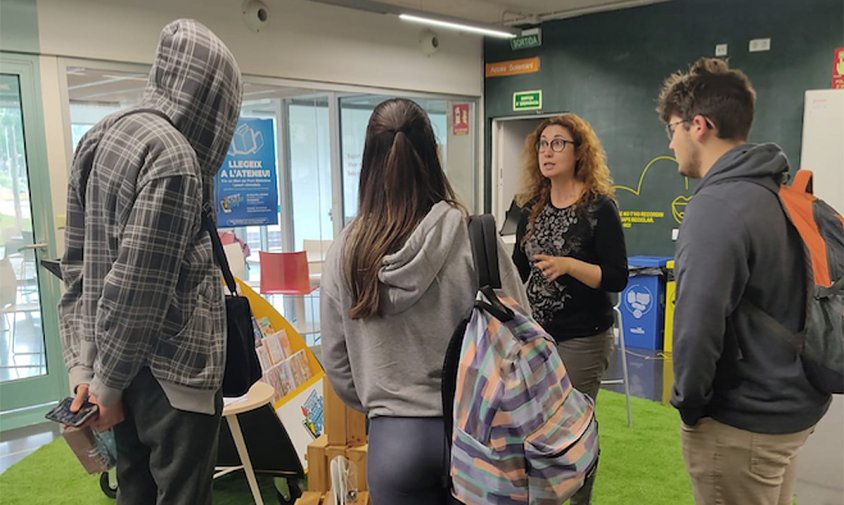 Diferents joves parlant amb la bibliotecària Rosana Andreu al servei Bibliojove de l'Ateneu