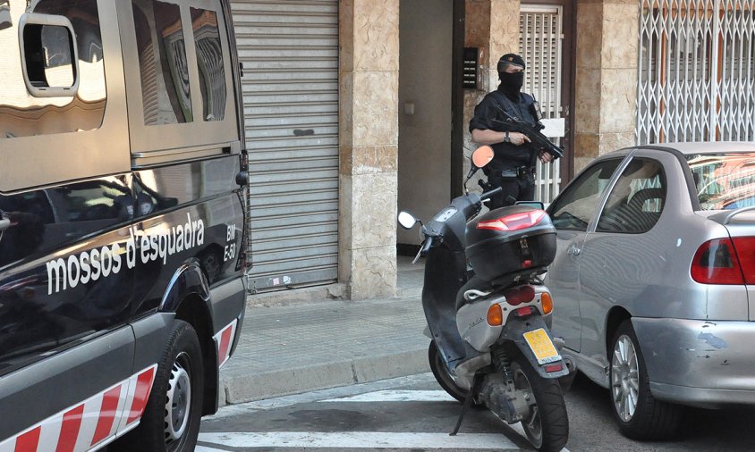 Agents dels Mossos davant la porta de l'edifici on es va produir la detenció, ahir a la tarda