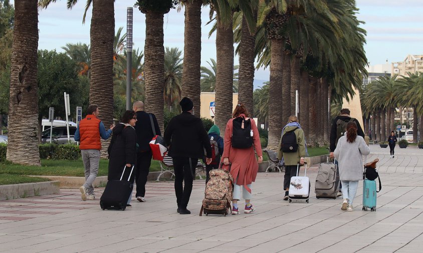 Un grup de gent amb malestes caminant pel passeig de Jaume I de Salou