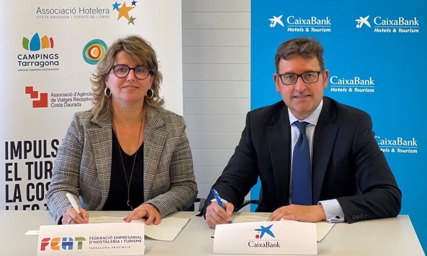 Berta Cabré, presidenta de la FEHT, signant l'acord juntament amb Josep Mª Gonzàlez,director territorial Catalunya de CaixaBank.