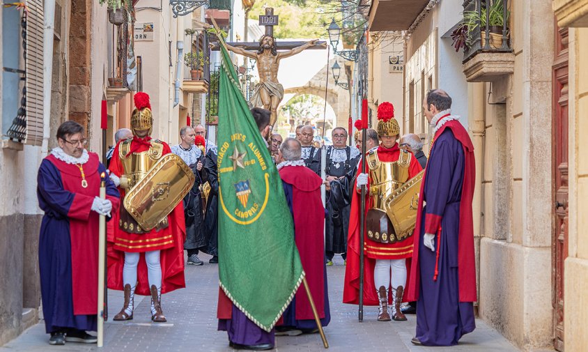 El viacrucis del Divendres Sant, aturat davant la novena estació amb la lona col·locada a l'edifici de l'esquerra de la fotografia