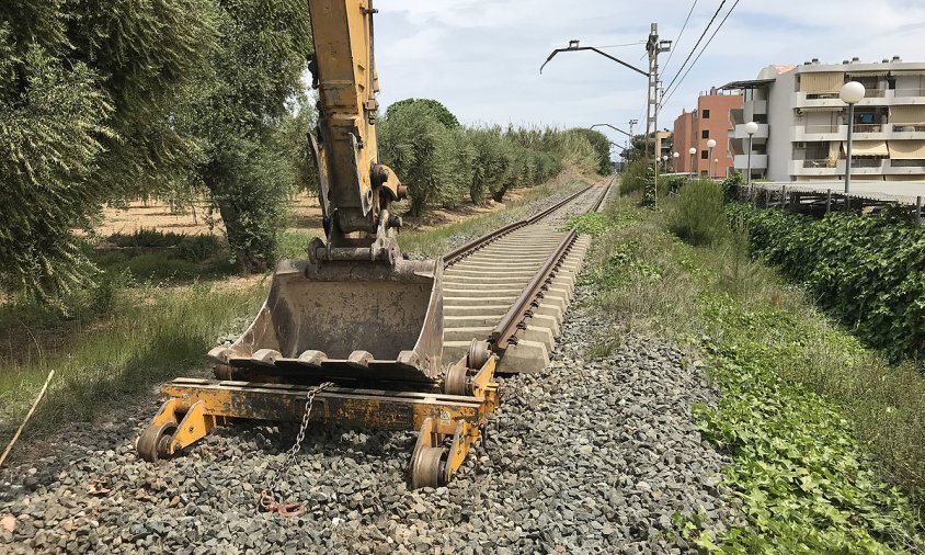 Màquina aturada davant d'un tram de via a punt de ser desmantellat, a Vilafortuny, prop de la benzinera