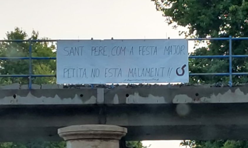 Pancarta col·locada a la barana del pont de l'antiga via fèrria