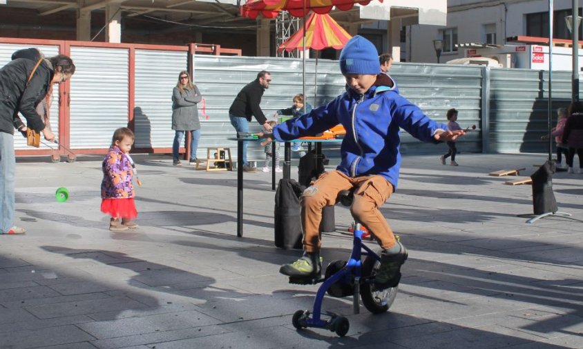 Nen jugant amb un tricicle a la plaça del Pòsit