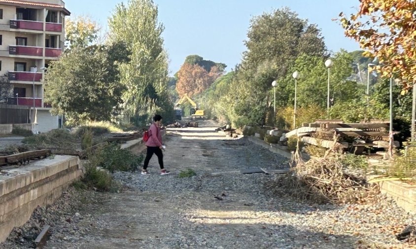 Una dona camina per l'antic traçat ferroviari que es convertirà en via verda