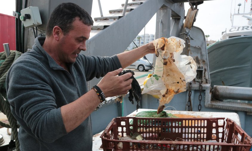 Un pescador de l'Ametlla de Mar retira trossos de plàstic, una de les deixalles més habituals que retiren del mar dins del projecte Pesca Neta