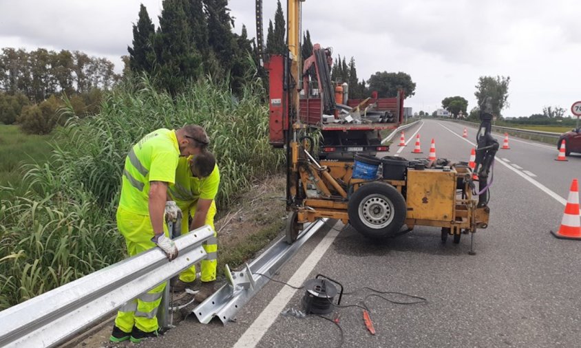 Dos operaris treballant en el manteniment d'una carretera