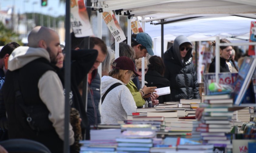 Vianants consultant llibres a les paradetes del Port