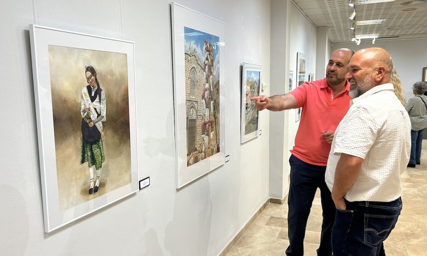 Juan Carlos Gil ensenya les seves aquarel·les als amics que van assistir ahir a la inauguració de l'exposició