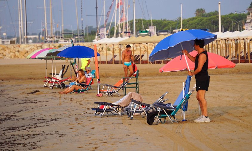 Un home instal·la cadires i para-sol a la platja del Regueral per, posteriorment, marxar