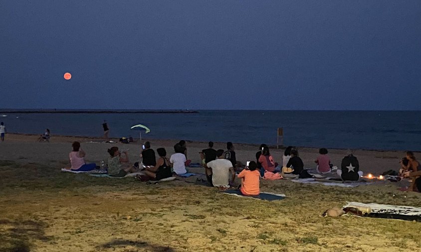 Persones observant la Superlluna Blava, a la platja del Cavet