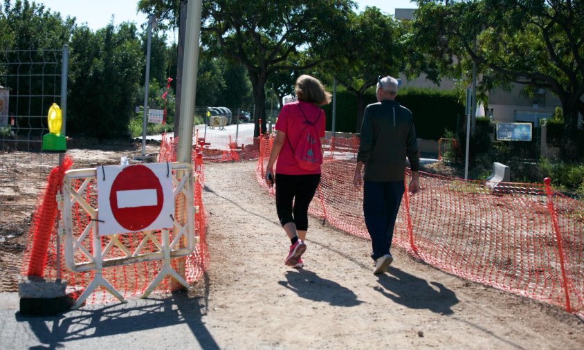 Dos persones creuant l'espai de l'antic pas a nivell durant les obres