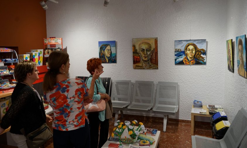 Laura Álvarez Keller mostra els seus quadres a dues visitants de l'exposició