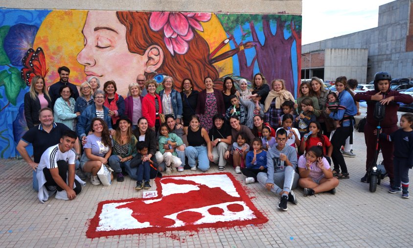 Autors del mural, veïns i autoritats davant de l'obra, ubicada a l'antiga estació