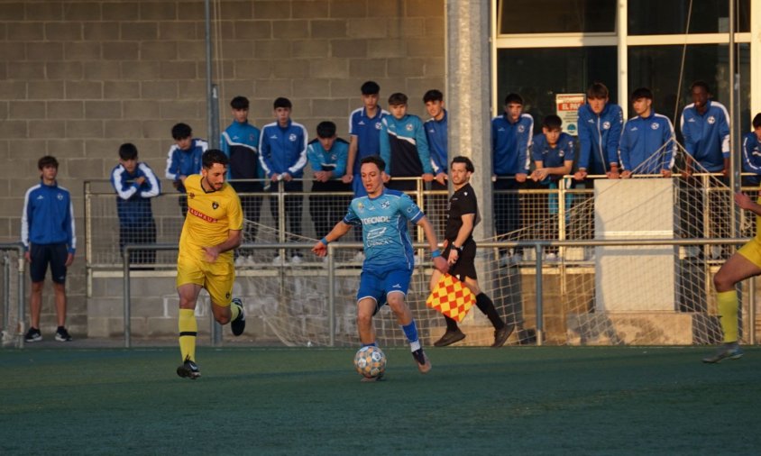 Richard regateja un defensa del Gavà mentre l'observen jugadors del futbol base del Cambrils Unió