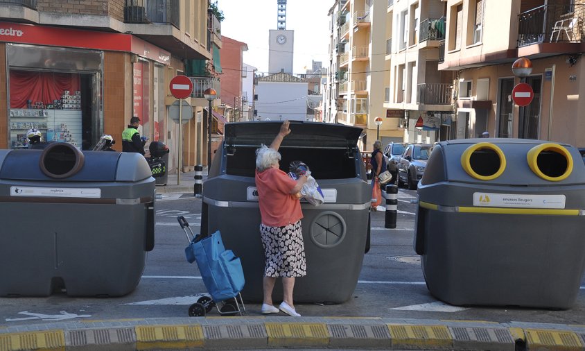 Una dona llança la brossa a un dels contenidors en superfície de l'Eixample Platja