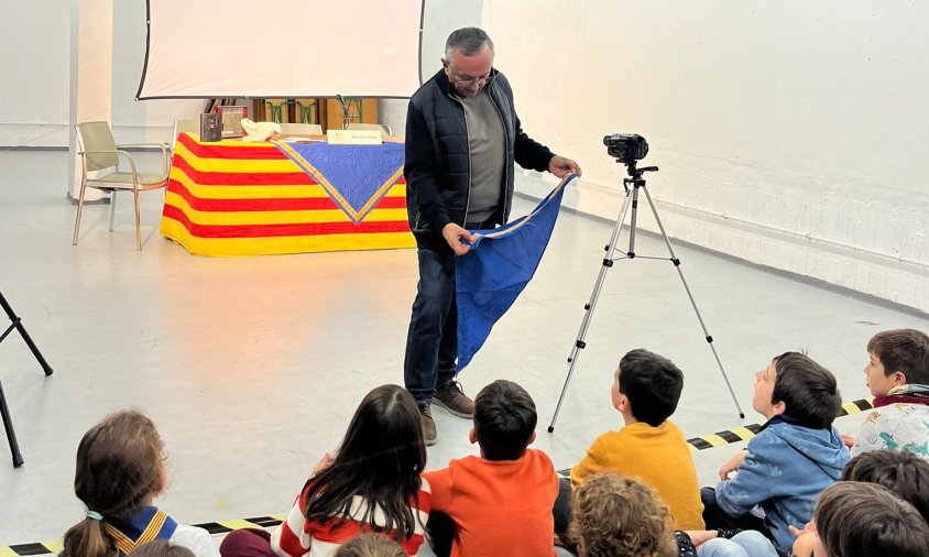 Josep Capella mostrant el seu fulard als nens i nenes