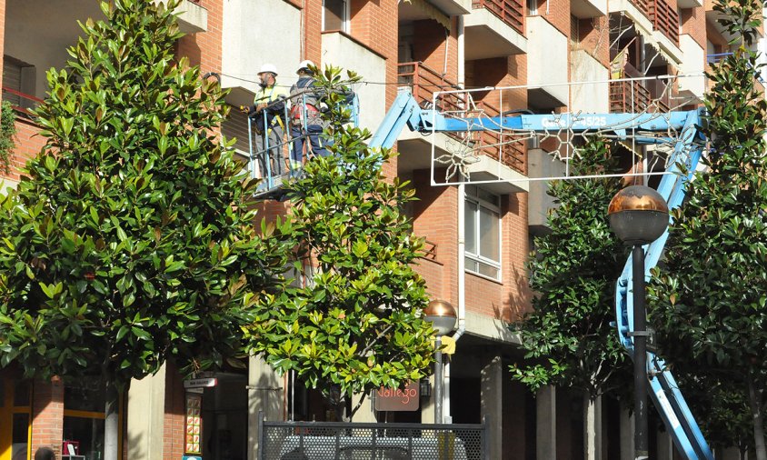 Imatge d'uns operaris muntant uns ornaments nadalencs al carrer de Pere III, la setmana passada