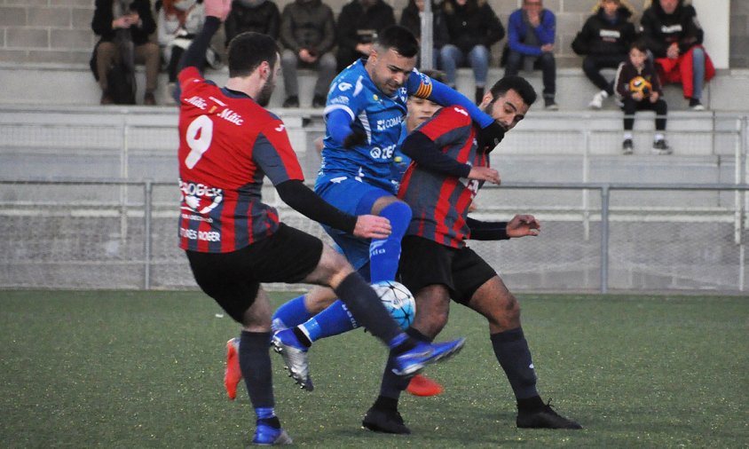 Nico, del Cambrils Unió, intenta passar per entremig de dos jugadors del Tàrrega