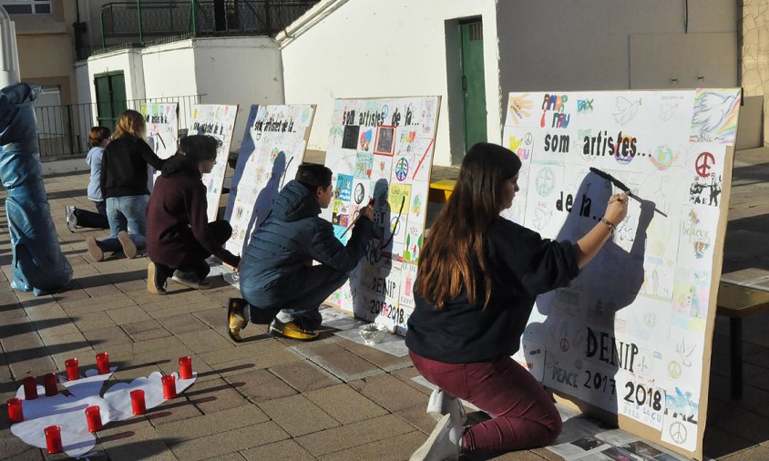 Uns alumnes van pintar amb pintura negra coloms de pau als murals que va fer tot l'alumnat d'ESO