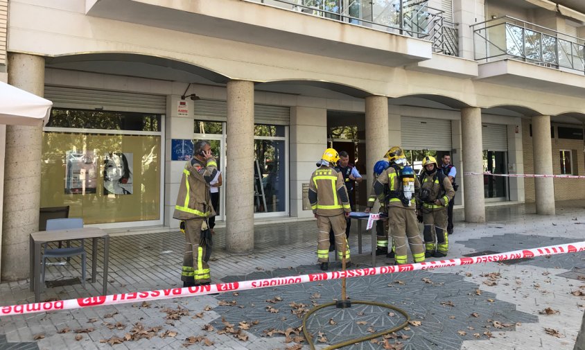 Bombers i Mossos davant la porta de l'immoble que ha patit l'incendi