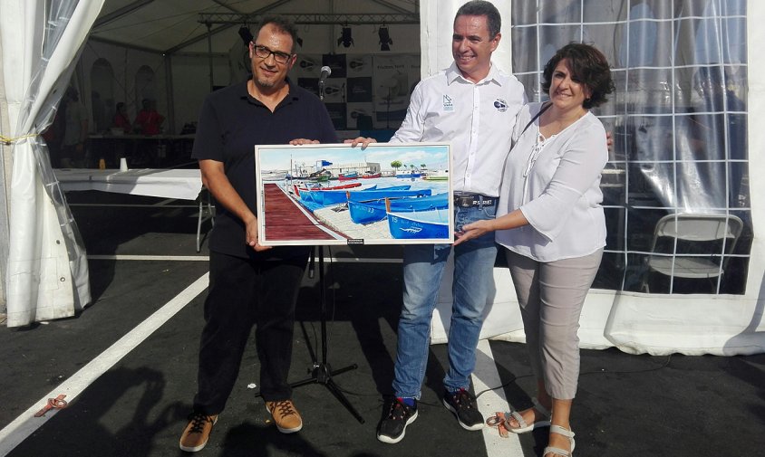 Carles Anguera, president dels Vent D'Estrop, i Anna M. Ollet lliuren el quadre commeoratiu al president del Club Nàutic Cambrils, Ramon Vallverdú