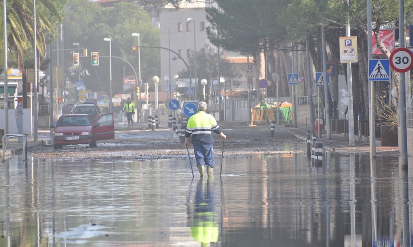 Operari al mig de l'avinguda de la Diputació, plena d'aigua