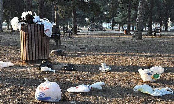 Aspecte del parc situat a l'avinguda de Mas Clariana. En un primer terme, una de les moltes papereres de la zona plena d'escombraries; al fons, el parc infantil