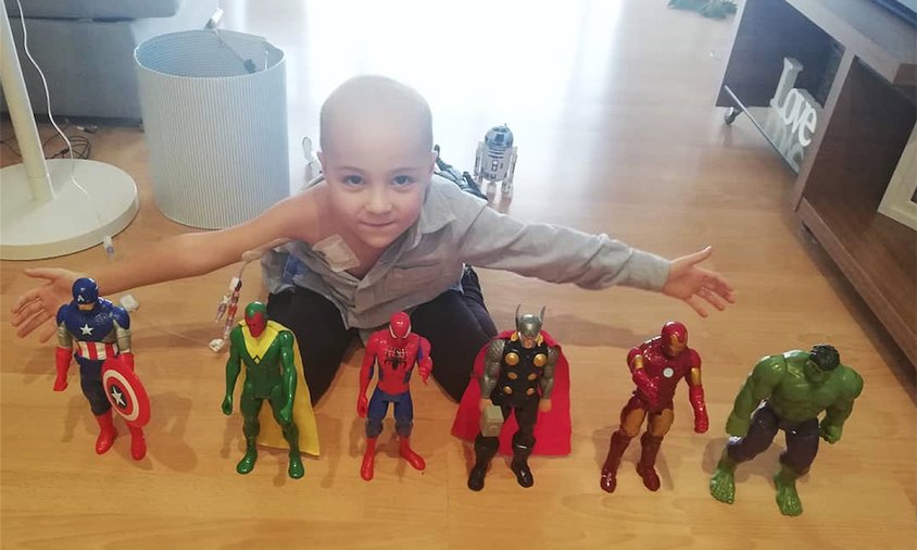 El petit gran guerrer Adrián Valadés amb la seva col·lecció de figures de superherois