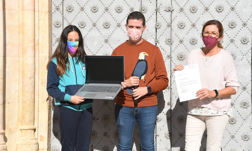 Karin Martí amb l'ordinador que se li ha lliurat com a guanyadora del concurs, al costat de Jose Garcia i Pilar Bas