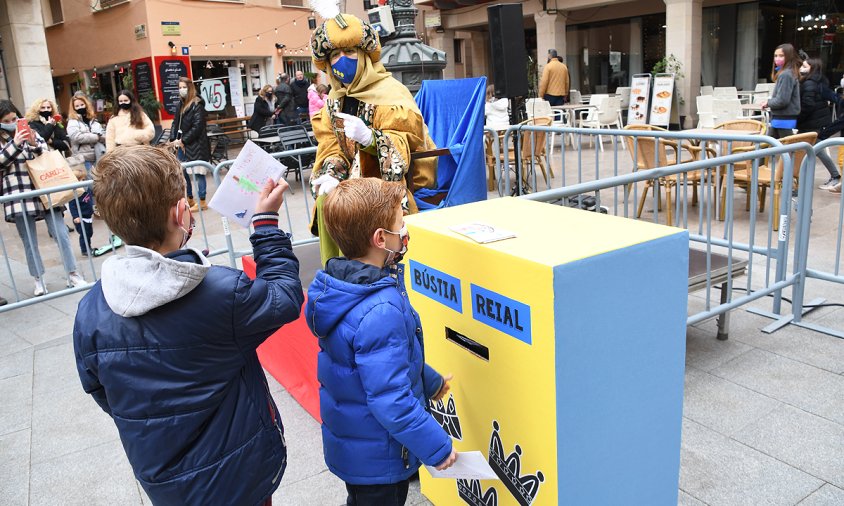 Uns xiquets dipositen la carta als Reis a la bústia ubicada, ahir, a la plaça de la Vila