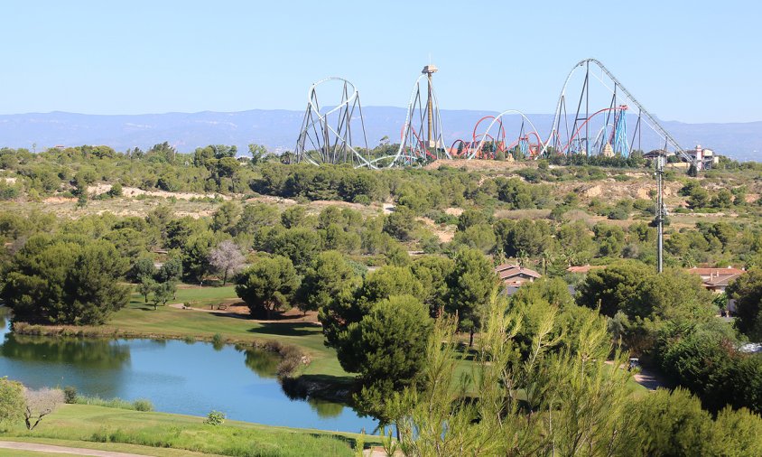 Terrenys del Centre Recreatiu i Turístic (CRT) de Vila-seca i Salou, amb un llac i camp de golf de PortAventura (Lumine) en primer terme, i les atraccions al fons