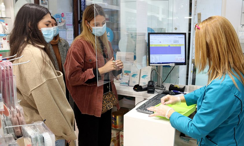 Imatge de diverses noies esperant el torn per fer-se un test d'antígens en una farmàcia